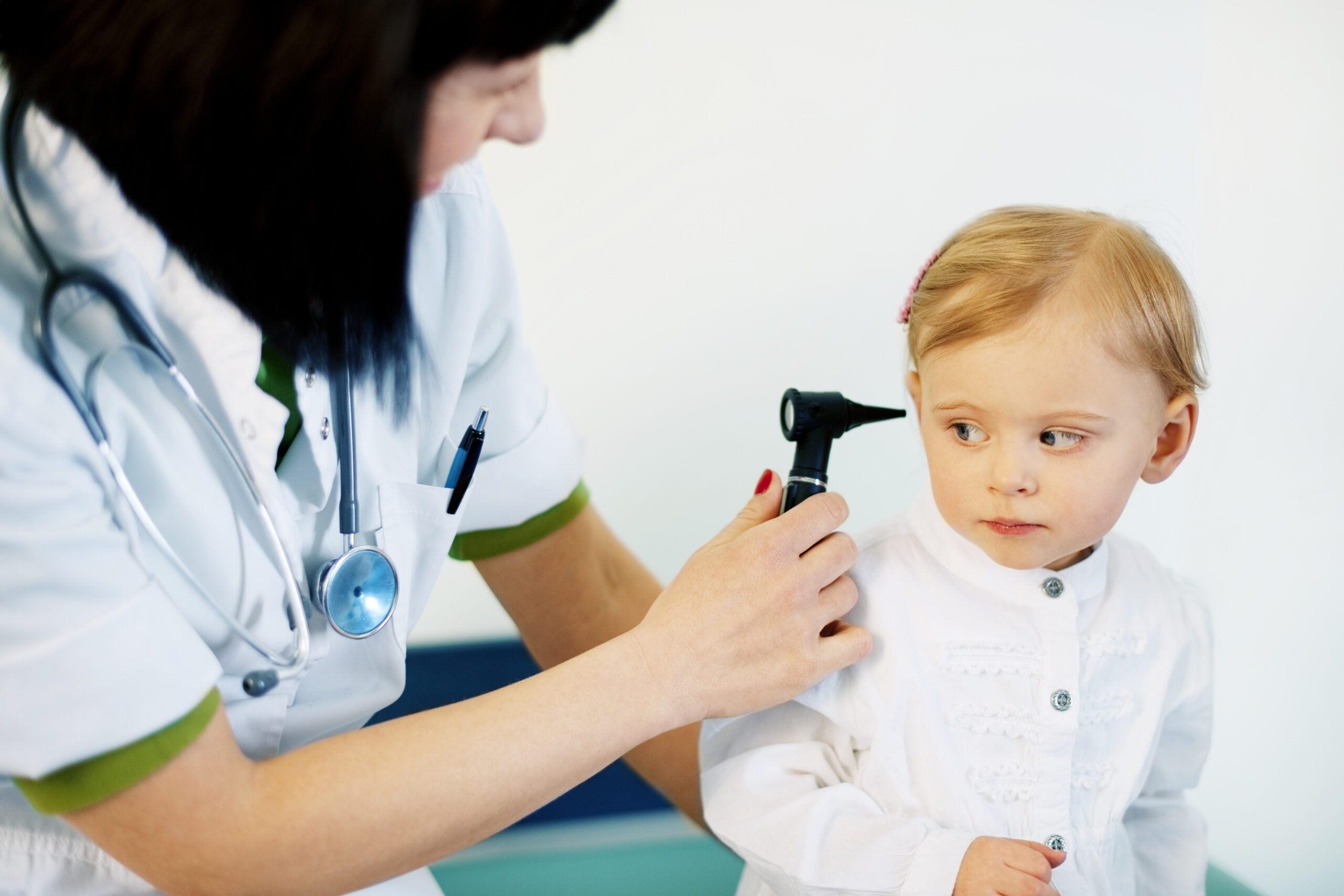 Pediatrician doing ear exam of baby girl