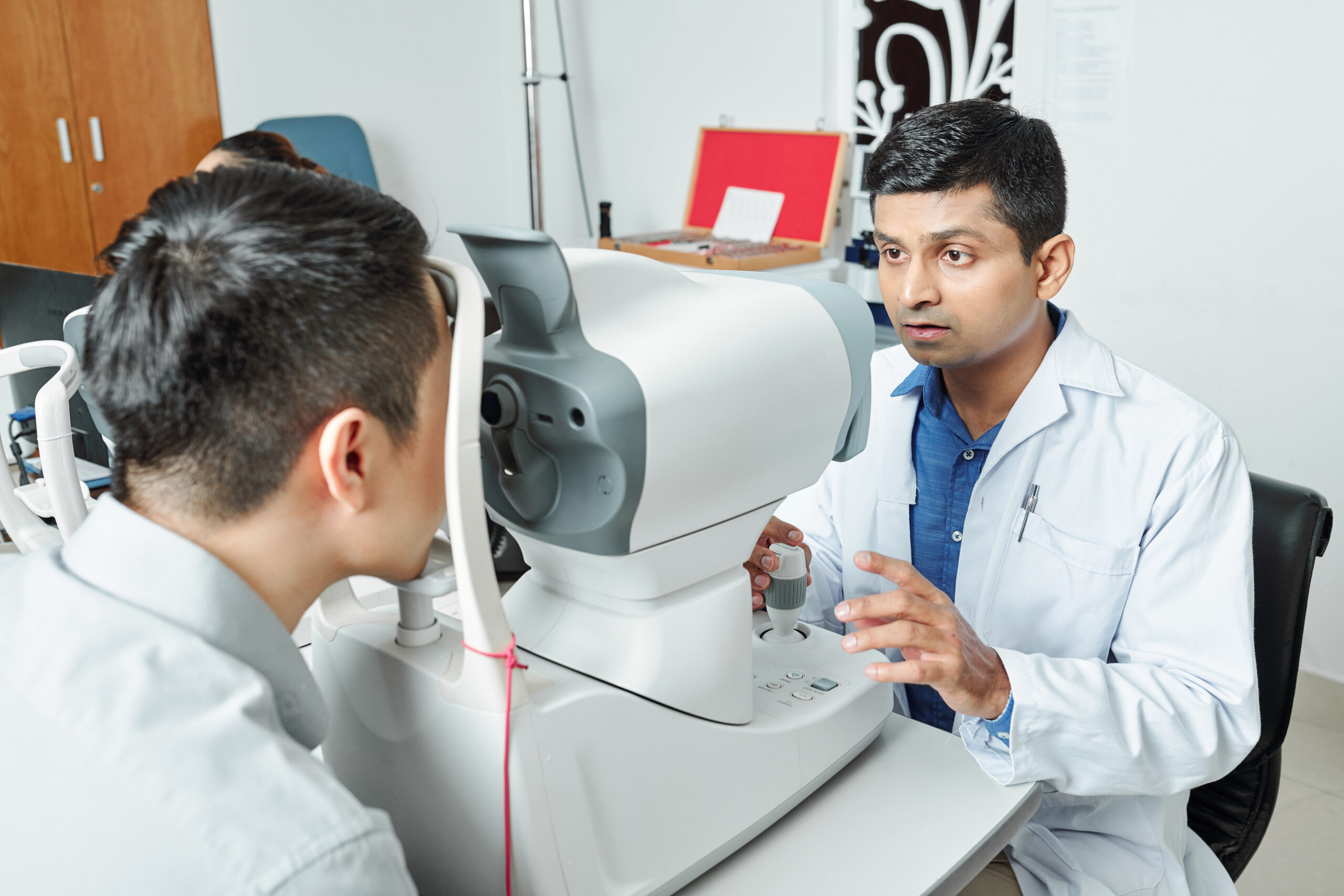 Experienced eye doctor in Kerala examining a patient’s eyes with advanced diagnostic equipment.